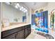 Charming bathroom with double vanity, granite countertop, and vibrant Disney-themed decor, offering a playful touch at 3142 Dark Sky Dr, Harmony, FL 34773