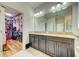Bathroom featuring double vanity with granite countertops and walk-in closet access at 3142 Dark Sky Dr, Harmony, FL 34773