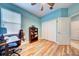 Light and airy bedroom with wood floors featuring a desk, chair, and built-in shelving at 3142 Dark Sky Dr, Harmony, FL 34773