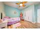 Charming bedroom with a decorative ceiling fan, wood floors, and an abundance of plush toys at 3142 Dark Sky Dr, Harmony, FL 34773