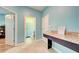 Light blue hallway with tile floors featuring a granite counter desk and bathroom access at 3142 Dark Sky Dr, Harmony, FL 34773