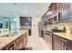 A kitchen with stainless steel appliances, dark wood cabinets, granite countertops and an island next to the dining area at 3142 Dark Sky Dr, Harmony, FL 34773