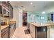 This kitchen offers stainless steel appliances, an island with granite countertops, dark wood cabinets, and open access to the dining area at 3142 Dark Sky Dr, Harmony, FL 34773