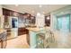 A spacious kitchen features stainless steel appliances, an island with granite countertops, and dark wood cabinets at 3142 Dark Sky Dr, Harmony, FL 34773