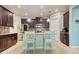 This kitchen features stainless steel appliances, granite countertops, an island with seating, and dark wood cabinets at 3142 Dark Sky Dr, Harmony, FL 34773