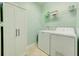 The laundry room features a washer, dryer, shelving, and a storage cabinet, making laundry tasks convenient at 3142 Dark Sky Dr, Harmony, FL 34773