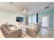 Cozy living room showcasing reclining furniture, ceiling fan, and natural light from the windows at 3142 Dark Sky Dr, Harmony, FL 34773