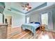 Main bedroom with wood floors, a ceiling fan, and a tray ceiling at 3142 Dark Sky Dr, Harmony, FL 34773