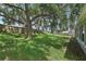 Well-maintained backyard with green grass, mature trees, and a partial view of the fenced perimeter at 3326 Sassaquin Ct, Orlando, FL 32818