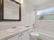 Well-lit bathroom featuring a single sink vanity, framed mirror, tub, and window at 3326 Sassaquin Ct, Orlando, FL 32818