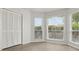 Bright bedroom featuring wood floors, three windows with blinds, and a double door closet at 3326 Sassaquin Ct, Orlando, FL 32818