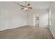 Bedroom with wood-look floors, ceiling fan, and ensuite bathroom, offering a peaceful retreat at 3326 Sassaquin Ct, Orlando, FL 32818