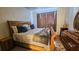 Bedroom featuring a wooden sleigh bed with decorative pillows and blanket, alongside a wooden dresser at 3379 S Kirkman Rd # 1027, Orlando, FL 32811