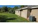 Exterior view of the home showing the siding, backyard, and HVAC unit at 35 Olive Cir, Ocala, FL 34472