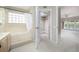 Bathroom with a soaking tub with glass block window and access to bedroom and walk-in closet at 3585 Ventura Club Cir, Orlando, FL 32822