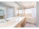 Bright bathroom featuring a double vanity, large mirror, and a combined tub and shower at 3585 Ventura Club Cir, Orlando, FL 32822