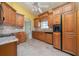 Traditional kitchen with wood cabinetry, tile backsplash, tile flooring, and sleek black appliances at 3585 Ventura Club Cir, Orlando, FL 32822