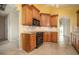 Well-appointed kitchen with dark appliances, wooden cabinets, and tile floors at 3585 Ventura Club Cir, Orlando, FL 32822