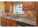 Kitchen with wood cabinets, neutral countertops, and a stainless steel sink under a window at 3585 Ventura Club Cir, Orlando, FL 32822