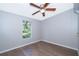 Bedroom features wood-look flooring, a ceiling fan, and a window with a peaceful outdoor view at 411 Racoon Trl, Geneva, FL 32732