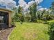 Spacious backyard with lush green grass, mature trees, and a black metal fence at 461 Brunswick Dr, Davenport, FL 33837