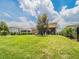 Spacious backyard featuring lush green grass, mature trees, and a view of neighboring homes at 461 Brunswick Dr, Davenport, FL 33837