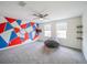Spacious bedroom featuring an unique wall design, carpet floors, ceiling fan and two windows at 461 Brunswick Dr, Davenport, FL 33837