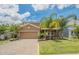 Lovely two-story home with a well-manicured lawn, mature landscaping, and a brick paver driveway at 461 Brunswick Dr, Davenport, FL 33837