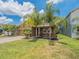 Beautiful home with lush landscaping, tropical plants, and a brick paver driveway at 461 Brunswick Dr, Davenport, FL 33837