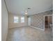 Open living area features neutral paint, decorative geometric walls, tile flooring, and a pet gate at 461 Brunswick Dr, Davenport, FL 33837