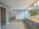 Bright bathroom with gray cabinets, dual sinks, walk-in shower, and large soaking tub at 461 Brunswick Dr, Davenport, FL 33837