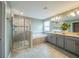 Bathroom featuring double sinks, soaking tub, and glass shower, offering a relaxing experience at 461 Brunswick Dr, Davenport, FL 33837