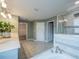 Bright bathroom with dual sinks, bathtub, shower, and tiled floor in an en-suite design at 461 Brunswick Dr, Davenport, FL 33837