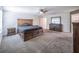 Well-lit main bedroom featuring carpet, a large wooden bed frame, and windows for natural light at 461 Brunswick Dr, Davenport, FL 33837