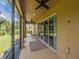 Spacious screened-in patio with ceiling fans, perfect for enjoying the outdoors, featuring a view of the green lawn at 461 Brunswick Dr, Davenport, FL 33837