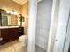 Bathroom with toilet next to open cabinet and a view of the vanity and mirror at 500 Wellesly St, Oviedo, FL 32765