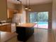 Bright kitchen featuring a kitchen island, a refrigerator, and sliding glass doors to the backyard at 500 Wellesly St, Oviedo, FL 32765