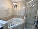 Bathroom with a soaking tub, a glass-enclosed shower, and elegant lighting at 506 Terrace Spring Dr, Orlando, FL 32828