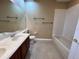 Bright bathroom featuring a double sink vanity, tile floors, and a bathtub at 506 Terrace Spring Dr, Orlando, FL 32828