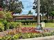 Woodland Terrace entrance sign surrounded by vibrant flowers and lush greenery at 506 Terrace Spring Dr, Orlando, FL 32828
