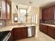 Modern kitchen featuring stainless appliances, wood cabinets, tile floors, and granite countertops at 506 Terrace Spring Dr, Orlando, FL 32828