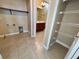 Laundry room with tiled floors, shelving and washer hookups next to bathroom at 506 Terrace Spring Dr, Orlando, FL 32828