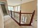 Open loft area with neutral carpet and decorative staircase railing at 506 Terrace Spring Dr, Orlando, FL 32828
