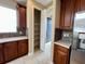 Kitchen with walk-in pantry, wood cabinets, stainless refrigerator, and tile flooring at 506 Terrace Spring Dr, Orlando, FL 32828