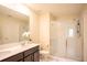 Modern bathroom with double sink vanity, quartz countertops, and a glass-enclosed shower at 561 Andrea S Cir, Haines City, FL 33844
