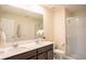 Bright bathroom featuring a double vanity, quartz countertop, and a glass-enclosed shower at 561 Andrea S Cir, Haines City, FL 33844