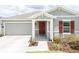 Charming home featuring a red front door, gray siding, and a covered entryway at 561 Andrea S Cir, Haines City, FL 33844