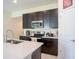 Kitchen featuring modern dark cabinets, stainless steel appliances, and a light countertop at 561 Andrea S Cir, Haines City, FL 33844