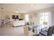 Open-concept living room and dining area with a white sofa, glass table, and mounted television at 561 Andrea S Cir, Haines City, FL 33844