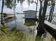 Charming boathouse extending over the water, set amidst mature trees and providing direct lake access at 606 Butler St, Windermere, FL 34786